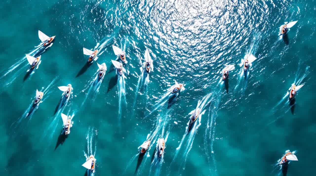 Aerial photograph of a regatta fleet rounding a turning mark on sunlit turquoise sea